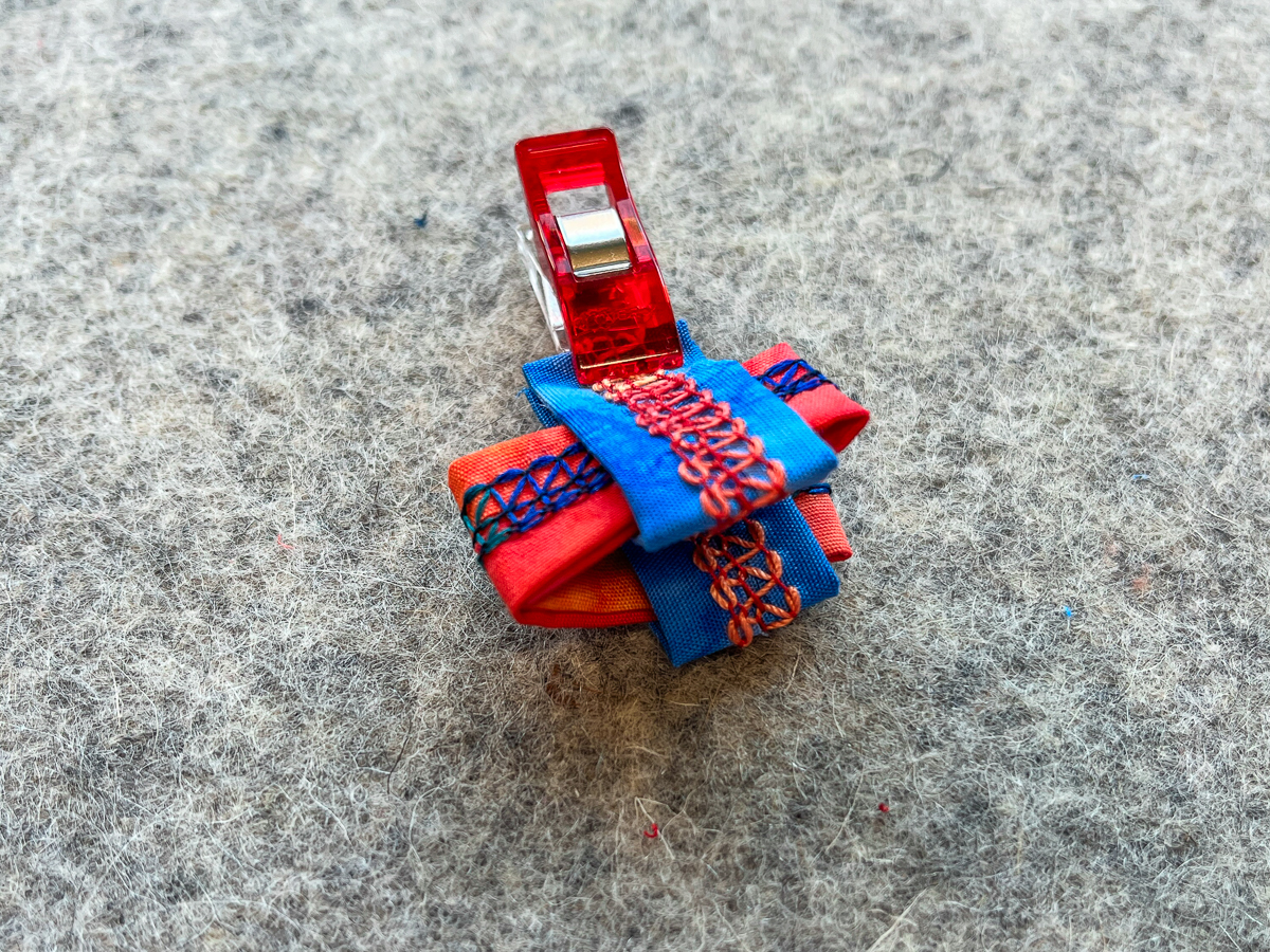 Slide the folded orange pieces into the fold openings of the blue piece, as shown