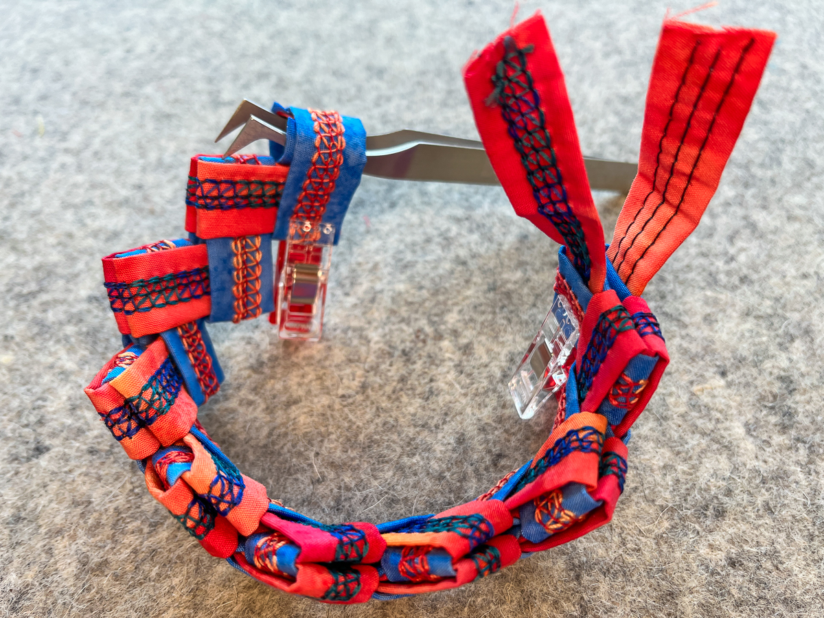 Using tweezers to full the fabric through