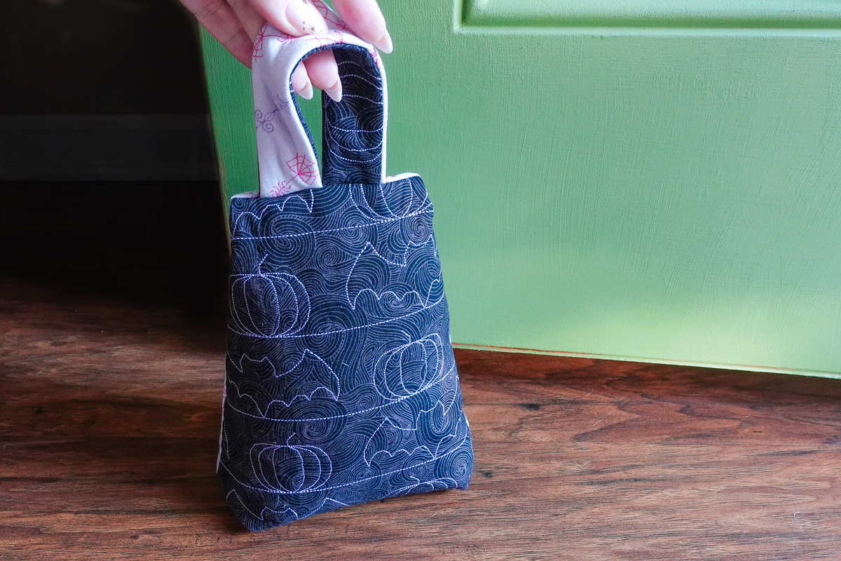 Halloween doorstop with bats leaning against a green door