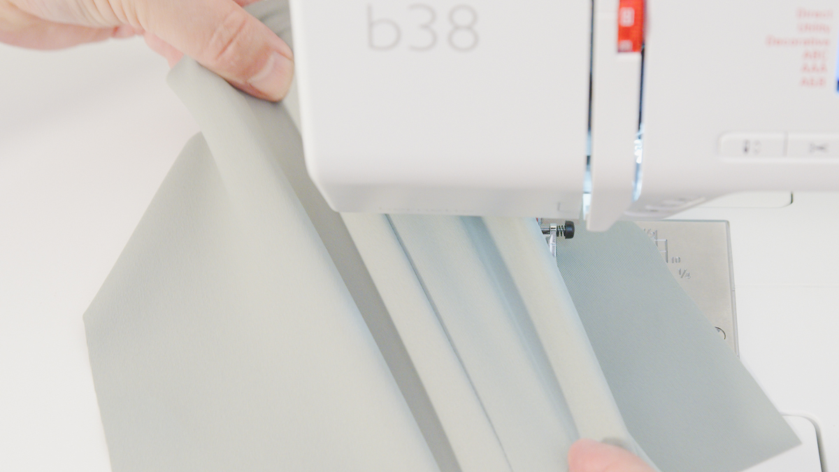 stretching light green spandex underneath a bernette 38 sewing machine