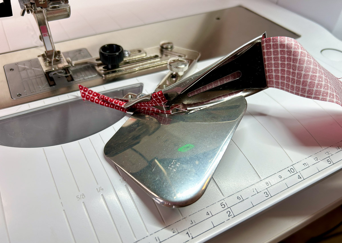 close up view of fabric being pulled through a binder attachement.