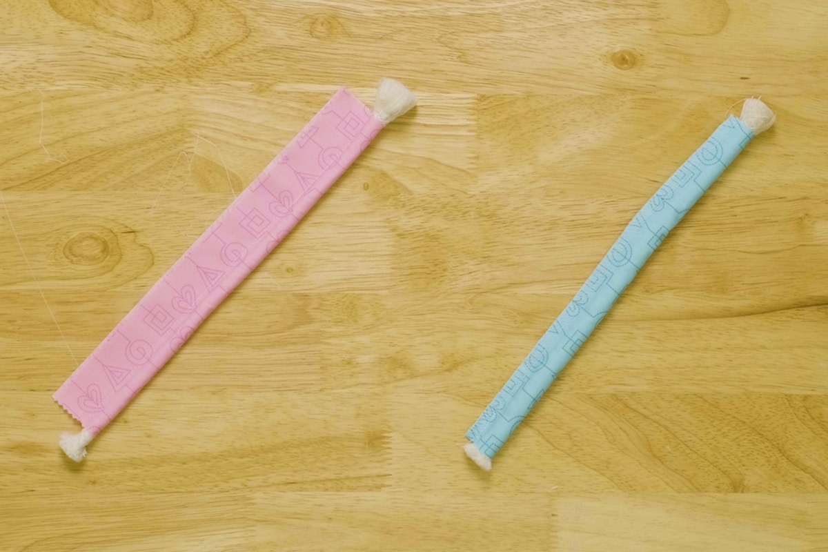 Pink and blue piping side-by-side on a wood background.
