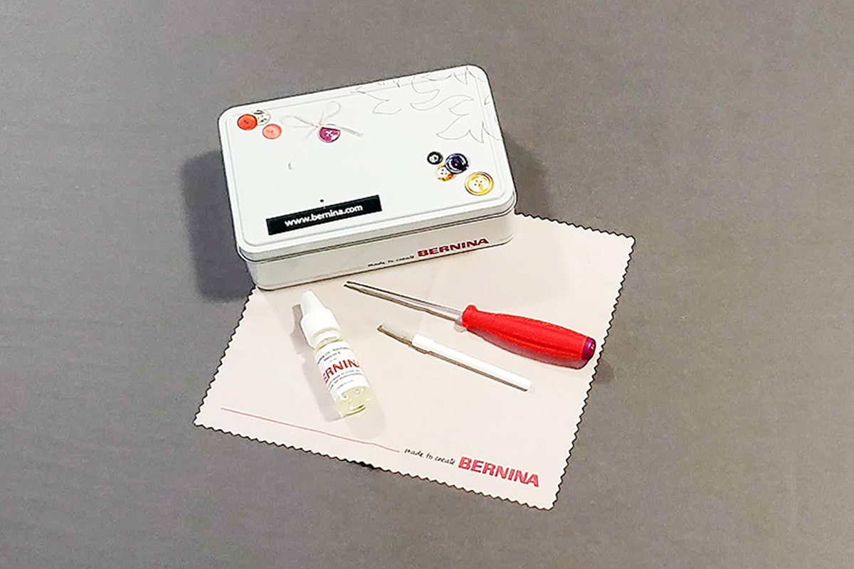 Oil, Brush, Wrench, Metal Tin and Cleaning Rag on Gray Background