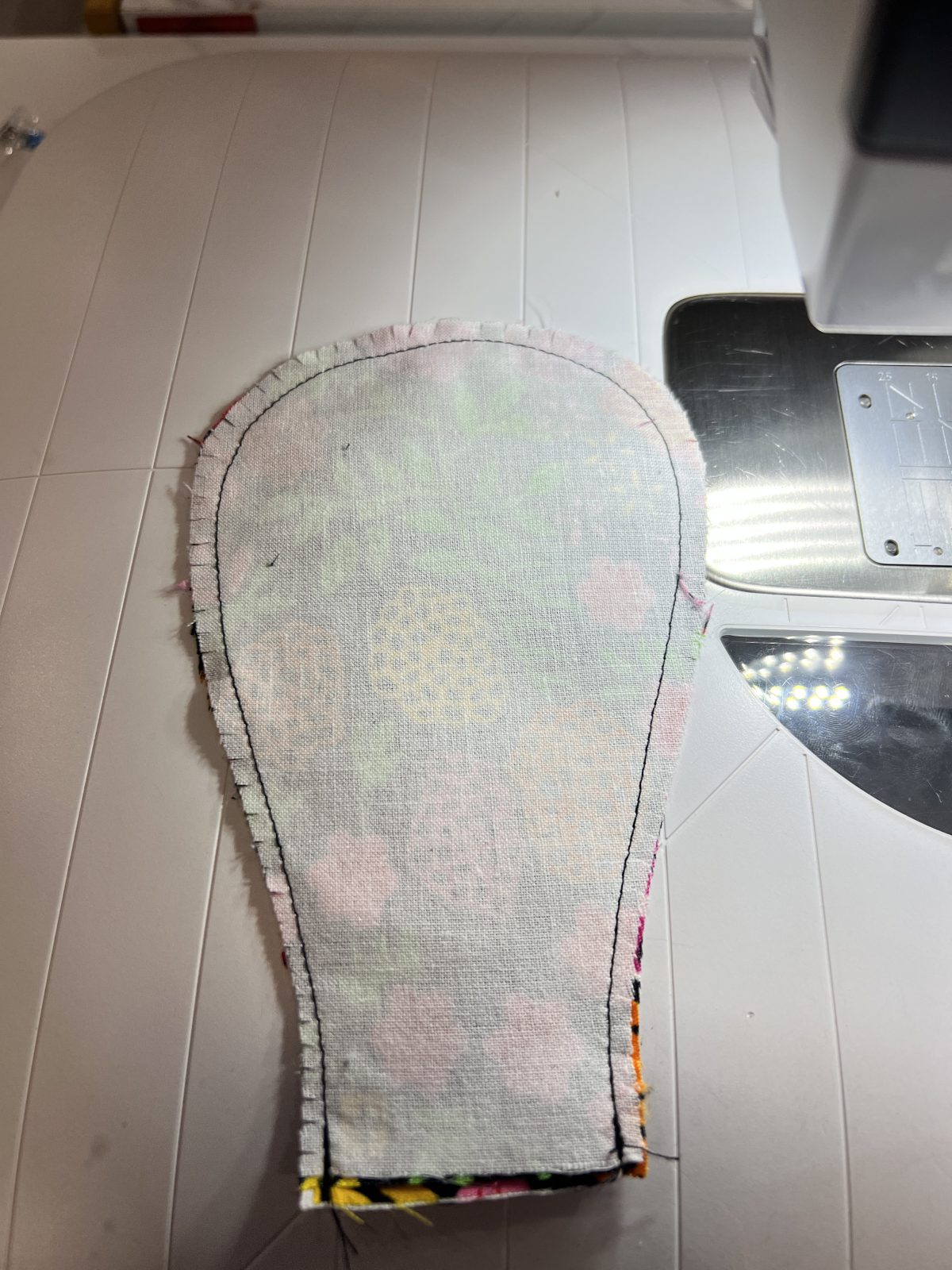 Sewn floral Ankara fabric petal shown wrong side out with small clips cut into the curved seam allowance before turning the petal right side out.